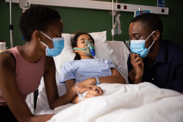 african anxious couple sits near their daughters bed hospital ward her face covered by_616370 5390